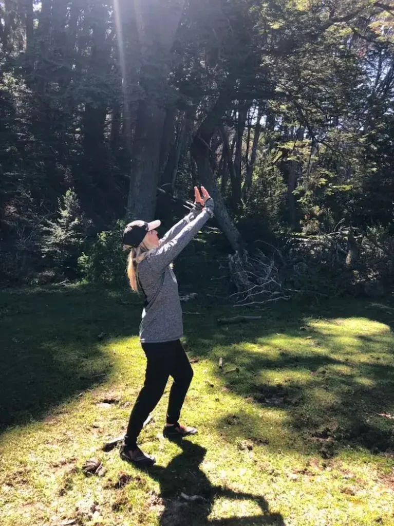 Mujer alzando sus manos hacia el sol.