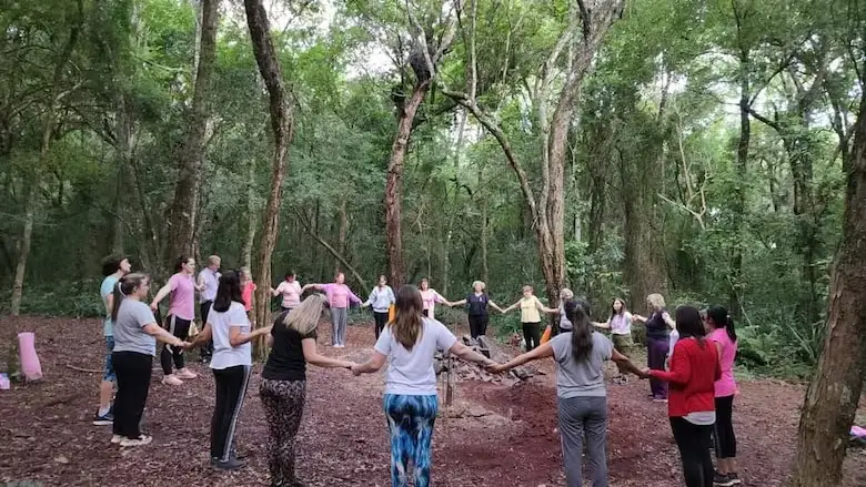 Personas en círculo en medio practicando Baño de Bosque.